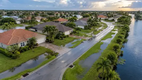 An aerial view of a neighbourhood after a storm with water held in grassy swales, street inlets and a canal alongside